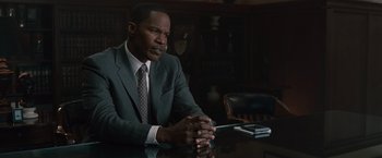 Movie still from “Law Abiding Citizen” (2009), directed by F. Gary Gray – A man sitting at a table in front of a phone; Medium shot, Low angle