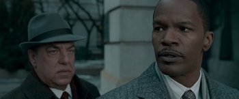 Movie still from “Law Abiding Citizen” (2009), directed by F. Gary Gray – A man in a suit and hat standing next to another man in a suit and hat; Close Up shot, Over the shoulder angle