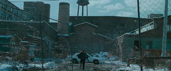Movie still from “Law Abiding Citizen” (2009), directed by F. Gary Gray – A man walking in front of an abandoned building; Extreme Wide shot, High angle