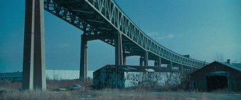 Movie still from “Law Abiding Citizen” (2009), directed by F. Gary Gray – An overpass over a river with cars parked under it; Extreme Wide shot, High angle