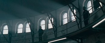 Movie still from “Law Abiding Citizen” (2009), directed by F. Gary Gray – A man standing on a balcony looking out the windows; Extreme Wide shot, Low angle