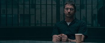Movie still from “Law Abiding Citizen” (2009), directed by F. Gary Gray – A man sitting at a table in front of a window; Close Up shot, Low angle