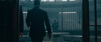 Movie still from “Law Abiding Citizen” (2009), directed by F. Gary Gray – A man in a suit is walking away from a jail cell; Wide shot, Over the shoulder angle