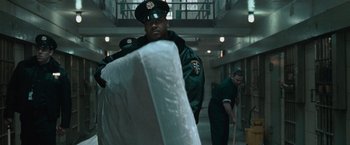 Movie still from “Law Abiding Citizen” (2009), directed by F. Gary Gray – A man in a green uniform is holding a mattress; Medium shot, Low angle