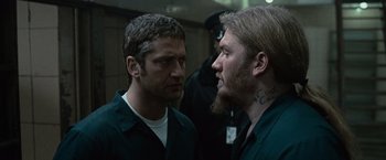 Movie still from “Law Abiding Citizen” (2009), directed by F. Gary Gray – Two men are facing each other in front of a group of people; Close Up shot, Over the shoulder angle