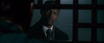 Movie still from “Law Abiding Citizen” (2009), directed by F. Gary Gray – A man wearing a suit and tie in front of a window; Close Up shot, Over the shoulder angle