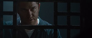 Movie still from “Law Abiding Citizen” (2009), directed by F. Gary Gray – A man in a jail cell looking through bars; Close Up shot, Over the shoulder angle