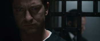 Movie still from “Law Abiding Citizen” (2009), directed by F. Gary Gray – A man's face in front of a jail cell; Close Up shot, Over the shoulder angle