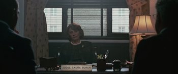 Movie still from “Law Abiding Citizen” (2009), directed by F. Gary Gray – A woman sitting at a table in front of a window; Medium shot, Over the shoulder angle