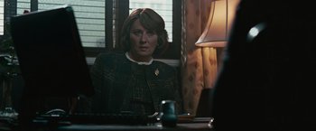 Movie still from “Law Abiding Citizen” (2009), directed by F. Gary Gray – A woman sitting in front of a lamp in front of a window; Medium shot, Over the shoulder angle