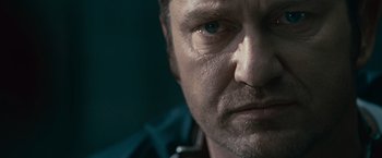 Movie still from “Law Abiding Citizen” (2009), directed by F. Gary Gray – A man's face in a dark room; Extreme Close Up shot, Over the shoulder angle