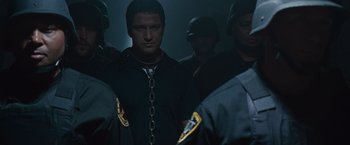 Movie still from “Law Abiding Citizen” (2009), directed by F. Gary Gray – A group of men standing next to each other in the dark; Medium shot, Low angle