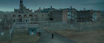 Movie still from “Law Abiding Citizen” (2009), directed by F. Gary Gray – Two men standing in a fenced in yard; Extreme Wide shot, High angle