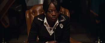 Movie still from “Law Abiding Citizen” (2009), directed by F. Gary Gray – A person sitting in a chair wearing a suit; Close Up shot, Over the shoulder angle