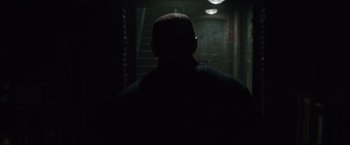 Movie still from “Law Abiding Citizen” (2009), directed by F. Gary Gray – A man standing in the dark in a dark room; Close Up shot, Over the shoulder angle