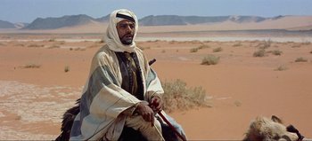 Movie still from “Lawrence of Arabia” (1962), directed by David Lean – A man sitting on top of a horse in the desert; Medium shot, Over the shoulder angle