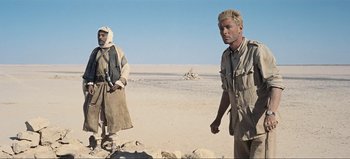 Movie still from “Lawrence of Arabia” (1962), directed by David Lean – Two men standing in the middle of the desert; Medium shot, Over the shoulder angle