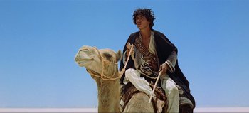 Movie still from “Lawrence of Arabia” (1962), directed by David Lean – A man sitting on top of a camel; Medium shot, Low angle