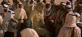 Movie still from “Lawrence of Arabia” (1962), directed by David Lean – A group of people in a desert area; Medium shot, Over the shoulder angle