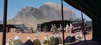 Movie still from “Lawrence of Arabia” (1962), directed by David Lean – A group of men sitting around a tent in the desert; Extreme Wide shot, Low angle
