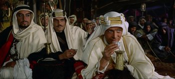 Movie still from “Lawrence of Arabia” (1962), directed by David Lean – Two men are dressed in white and are drinking tea; Medium shot, Over the shoulder angle