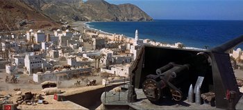 Movie still from “Lawrence of Arabia” (1962), directed by David Lean – An aerial view of a town with a beach in the background; Extreme Wide shot, High angle