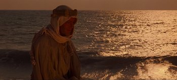 Movie still from “Lawrence of Arabia” (1962), directed by David Lean – A man standing on a beach near the ocean; Medium shot, Over the shoulder angle