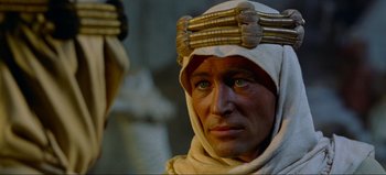 Movie still from “Lawrence of Arabia” (1962), directed by David Lean – A man in a costume is looking into the camera; Close Up shot, Over the shoulder angle