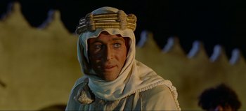 Movie still from “Lawrence of Arabia” (1962), directed by David Lean – A man wearing a white robe and a white turban; Close Up shot, Over the shoulder angle