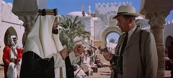 Movie still from “Lawrence of Arabia” (1962), directed by David Lean – Two men are standing in front of a building; Medium shot, Over the shoulder angle