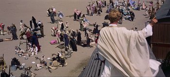 Movie still from “Lawrence of Arabia” (1962), directed by David Lean – A group of people gathered on the beach; Wide shot, High angle