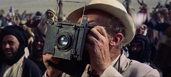Movie still from “Lawrence of Arabia” (1962), directed by David Lean – An older man taking a picture with an old camera; Extreme Close Up shot, Low angle