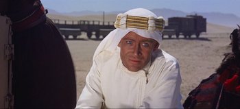 Movie still from “Lawrence of Arabia” (1962), directed by David Lean – A man wearing a white turban and a white shirt; Close Up shot, Over the shoulder angle