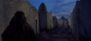 Movie still from “Lawrence of Arabia” (1962), directed by David Lean – An old stone building with a dome on the top of it; Wide shot, Low angle