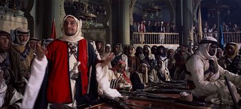 Movie still from “Lawrence of Arabia” (1962), directed by David Lean – A group of people sitting in a room with guns; Wide shot, High angle