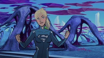 Movie still from “Legion of Super-Heroes” (2023), directed by Jeff Wamester – A woman standing in front of a building with trees in the background; Medium shot, Over the shoulder angle