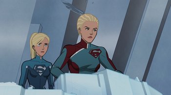 Movie still from “Legion of Super-Heroes” (2023), directed by Jeff Wamester – A woman in a red and blue suit stands next to another woman in a blue and red suit; Medium shot, Over the shoulder angle