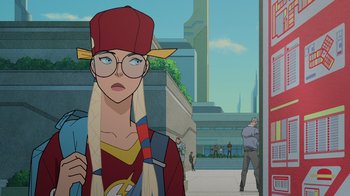 Movie still from “Legion of Super-Heroes” (2023), directed by Jeff Wamester – A woman with a hat and glasses is standing in front of a building; Medium shot, Over the shoulder angle