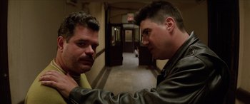 Movie still from “Léon: The Professional” (1994), directed by Luc Besson – Two men in leather jackets standing next to each other in a hallway; Close Up shot, Over the shoulder angle