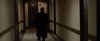 Movie still from “Léon: The Professional” (1994), directed by Luc Besson – A man walking down a hall way in a building; Wide shot, Low angle