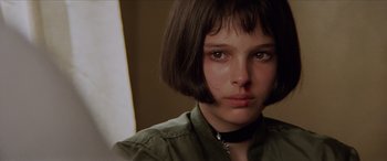 Movie still from “Léon: The Professional” (1994), directed by Luc Besson – A person with short black hair; Close Up shot, Over the shoulder angle