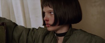 Movie still from “Léon: The Professional” (1994), directed by Luc Besson – A person wearing a necklace; Close Up shot, Low angle