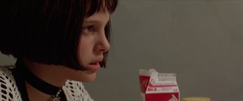 Movie still from “Léon: The Professional” (1994), directed by Luc Besson – A young woman looking at a box of milk; Close Up shot, Over the shoulder angle
