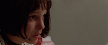 Movie still from “Léon: The Professional” (1994), directed by Luc Besson – A young girl is looking down at her face; Close Up shot, Over the shoulder angle