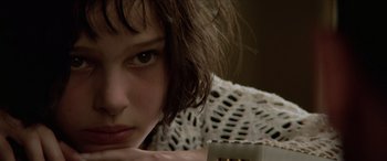 Movie still from “Léon: The Professional” (1994), directed by Luc Besson – A person with her hand on her chin; Close Up shot, Over the shoulder angle