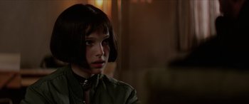 Movie still from “Léon: The Professional” (1994), directed by Luc Besson – A young woman with short brown hair wearing a green shirt; Close Up shot, Over the shoulder angle
