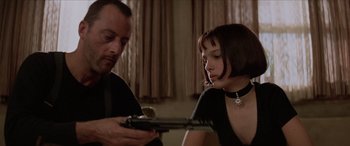 Movie still from “Léon: The Professional” (1994), directed by Luc Besson – A man and a woman looking at something on a table; Close Up shot, Low angle