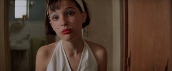 Movie still from “Léon: The Professional” (1994), directed by Luc Besson – A young woman wearing a white top and a headband; Close Up shot, High angle