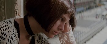 Movie still from “Léon: The Professional” (1994), directed by Luc Besson – A young woman with a white dress and a white necklace; Close Up shot, Low angle