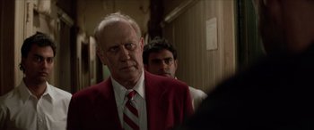 Movie still from “Léon: The Professional” (1994), directed by Luc Besson – An older man wearing a red jacket and a red tie; Close Up shot, Over the shoulder angle